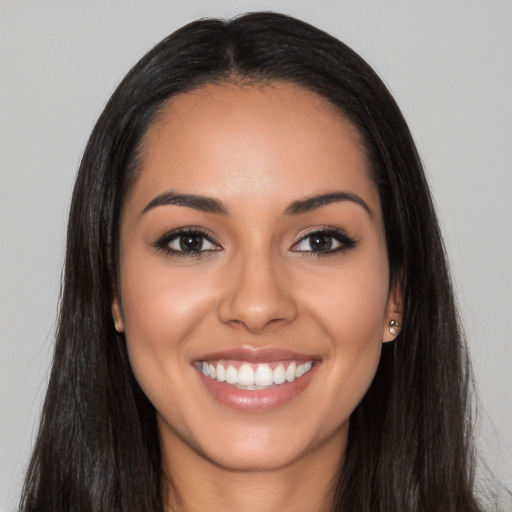 Joyful latino young-adult female with long  black hair and brown eyes