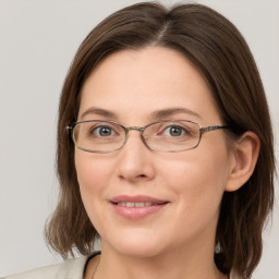 Joyful white adult female with medium  brown hair and grey eyes