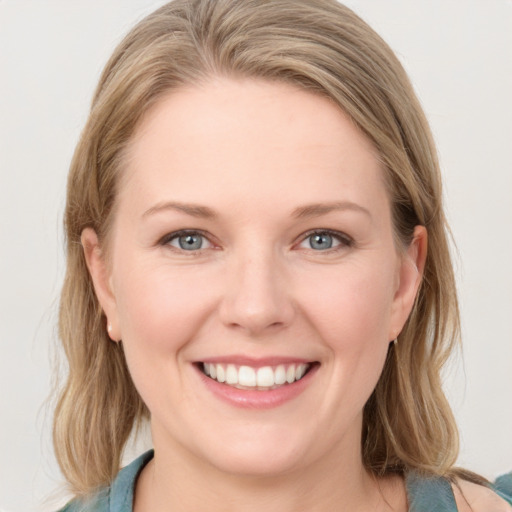 Joyful white young-adult female with medium  brown hair and blue eyes