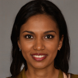 Joyful black young-adult female with long  brown hair and brown eyes