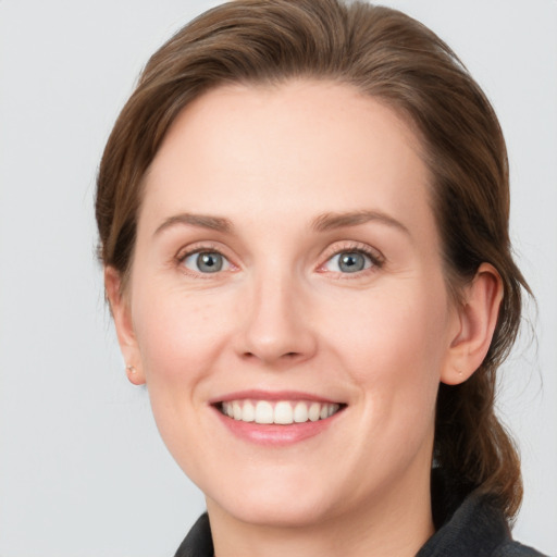 Joyful white young-adult female with medium  brown hair and blue eyes