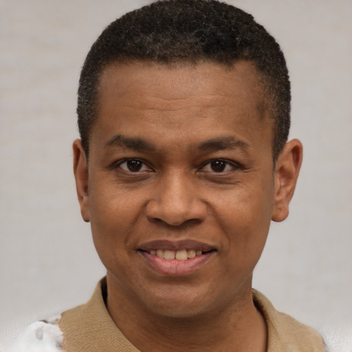 Joyful black adult male with short  brown hair and brown eyes