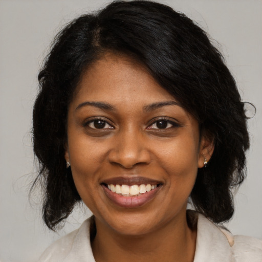 Joyful black young-adult female with medium  brown hair and brown eyes
