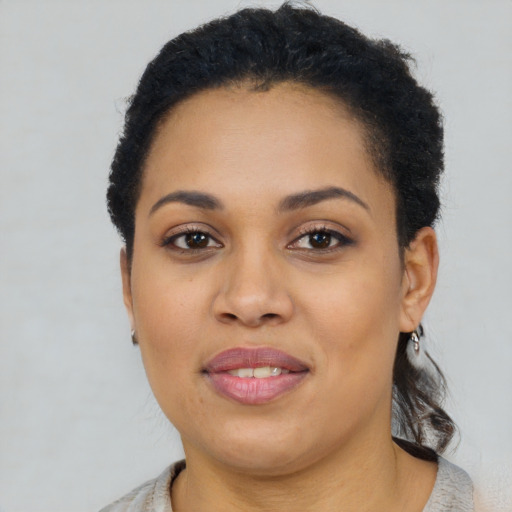 Joyful black young-adult female with short  brown hair and brown eyes
