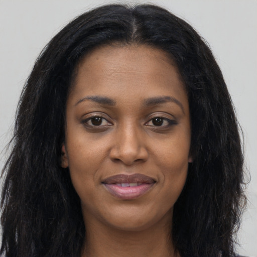 Joyful black young-adult female with long  black hair and brown eyes