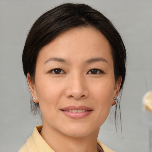 Joyful asian young-adult female with medium  brown hair and brown eyes