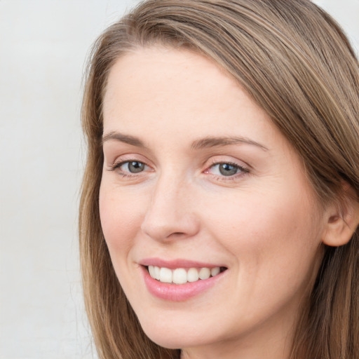 Joyful white young-adult female with long  brown hair and grey eyes