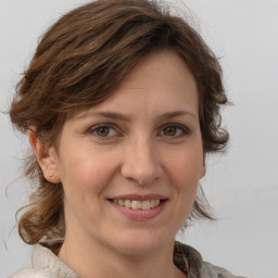 Joyful white adult female with medium  brown hair and grey eyes