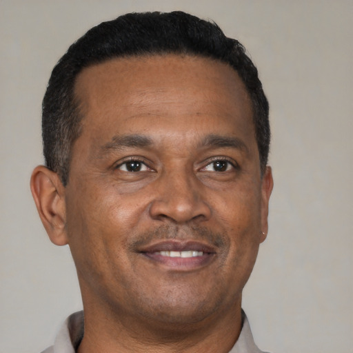 Joyful black adult male with short  brown hair and brown eyes