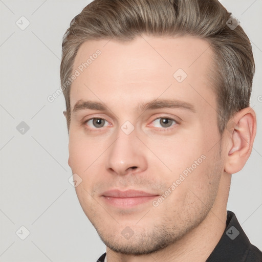 Joyful white young-adult male with short  brown hair and grey eyes