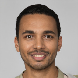 Joyful latino young-adult male with short  black hair and brown eyes