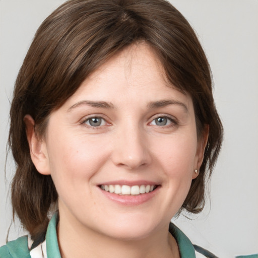 Joyful white young-adult female with medium  brown hair and grey eyes