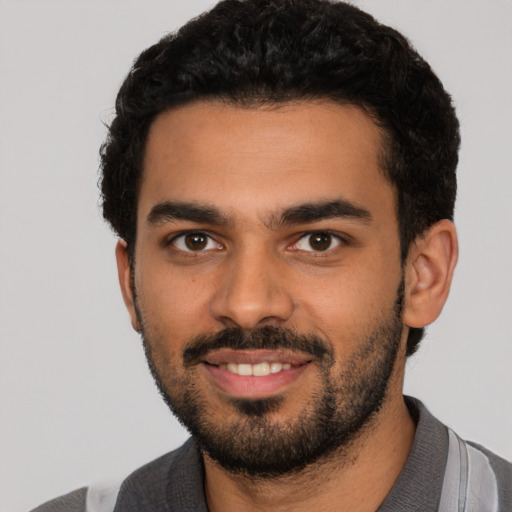 Joyful latino young-adult male with short  black hair and brown eyes