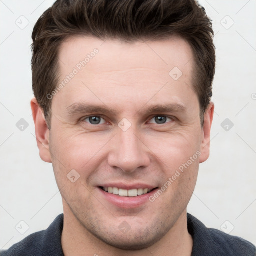 Joyful white young-adult male with short  brown hair and grey eyes