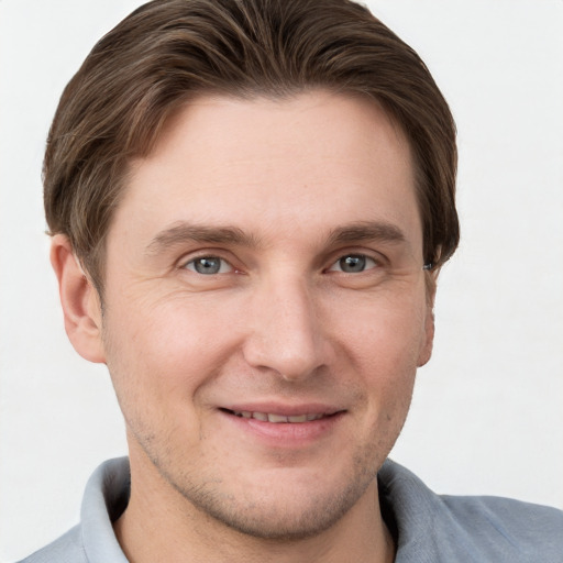 Joyful white young-adult male with short  brown hair and grey eyes