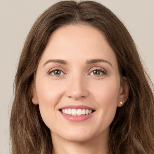 Joyful white young-adult female with long  brown hair and green eyes