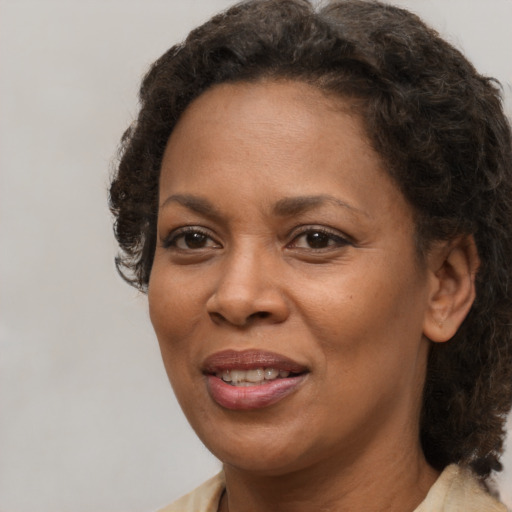 Joyful black adult female with medium  brown hair and brown eyes