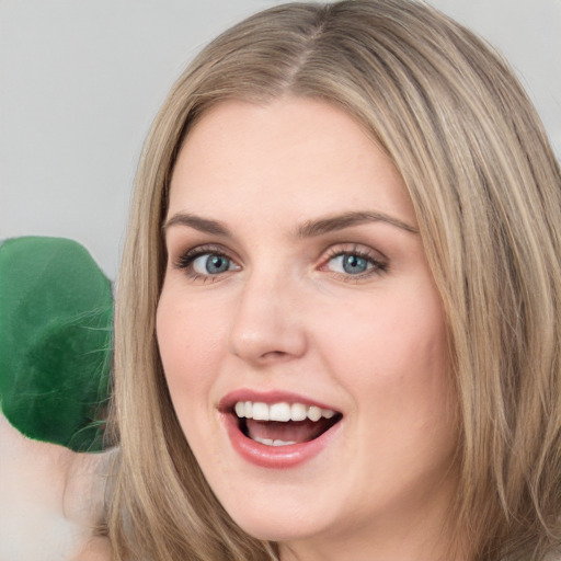 Joyful white young-adult female with long  brown hair and green eyes