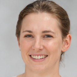 Joyful white adult female with medium  brown hair and grey eyes