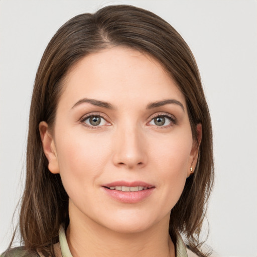 Joyful white young-adult female with medium  brown hair and grey eyes