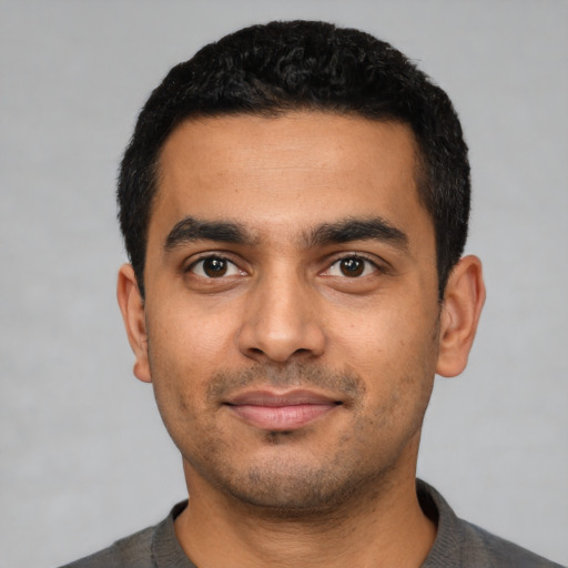 Joyful latino young-adult male with short  black hair and brown eyes