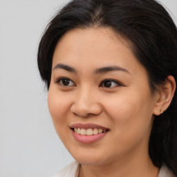 Joyful asian young-adult female with long  brown hair and brown eyes