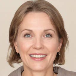 Joyful white adult female with medium  brown hair and grey eyes