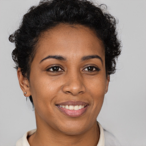 Joyful black young-adult female with short  brown hair and brown eyes