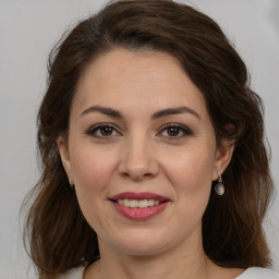 Joyful white adult female with medium  brown hair and brown eyes