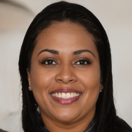 Joyful black young-adult female with long  black hair and brown eyes