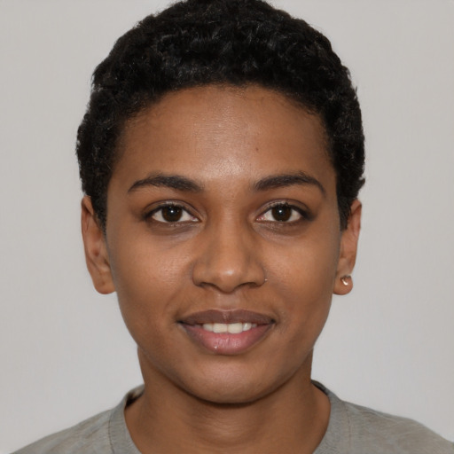 Joyful black young-adult female with short  black hair and brown eyes