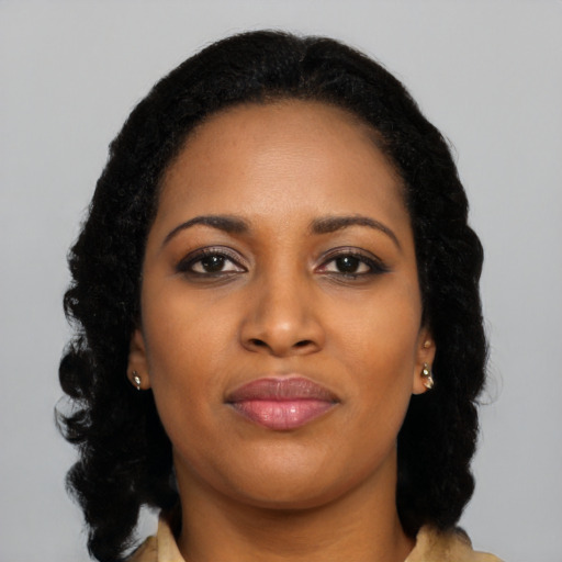 Joyful black young-adult female with long  black hair and brown eyes