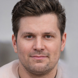 Joyful white adult male with short  brown hair and brown eyes