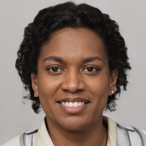 Joyful black young-adult female with short  brown hair and brown eyes
