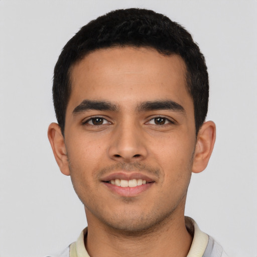 Joyful latino young-adult male with short  black hair and brown eyes