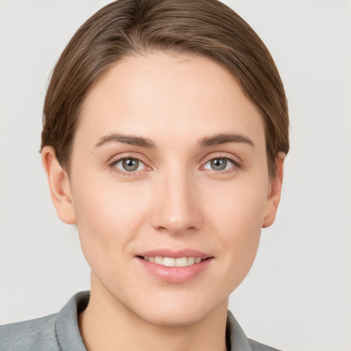 Joyful white young-adult female with short  brown hair and grey eyes