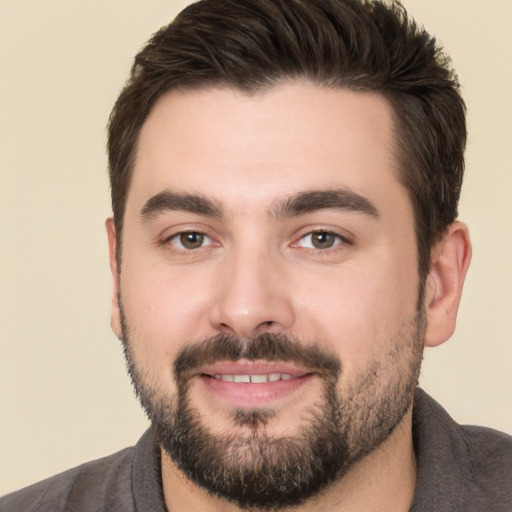 Joyful white young-adult male with short  black hair and brown eyes