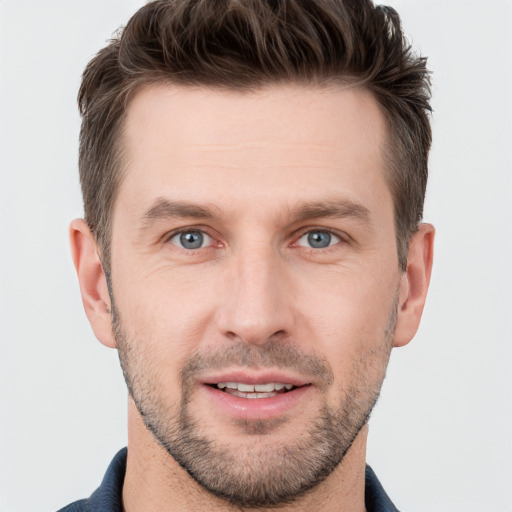 Joyful white young-adult male with short  brown hair and grey eyes