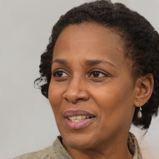 Joyful black adult female with short  brown hair and brown eyes