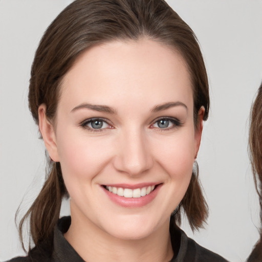 Joyful white young-adult female with medium  brown hair and grey eyes