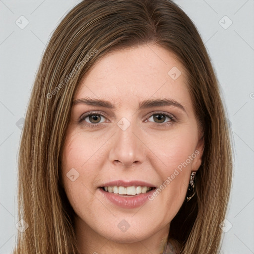 Joyful white young-adult female with long  brown hair and brown eyes