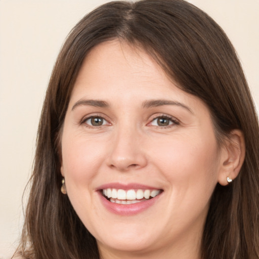 Joyful white young-adult female with long  brown hair and brown eyes