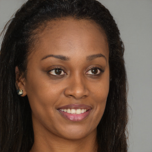 Joyful black young-adult female with long  brown hair and brown eyes