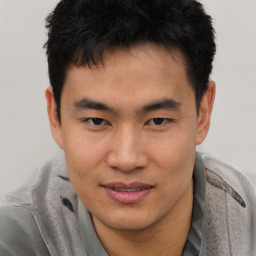 Joyful asian young-adult male with short  brown hair and brown eyes