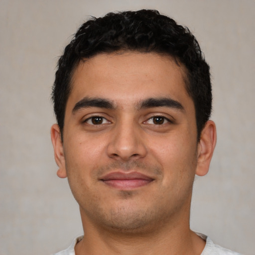 Joyful latino young-adult male with short  black hair and brown eyes