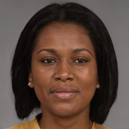 Joyful black young-adult female with long  brown hair and brown eyes