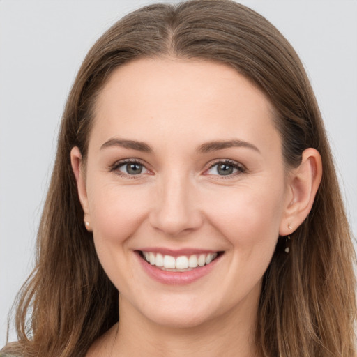 Joyful white young-adult female with long  brown hair and grey eyes