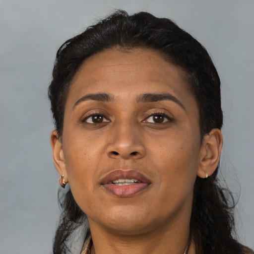 Joyful black adult female with long  brown hair and brown eyes