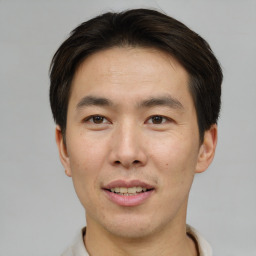 Joyful asian young-adult male with short  brown hair and brown eyes