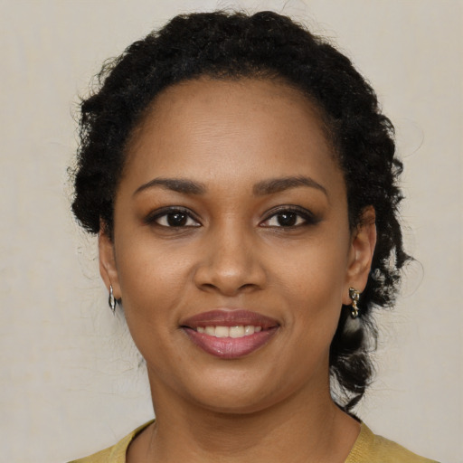 Joyful black young-adult female with long  brown hair and brown eyes